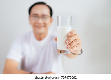 Senior Asian Man Holding A Glass Of Milk