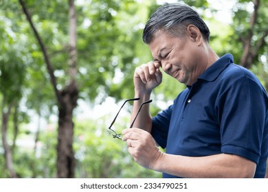 Senior Asian Man holding unfit glasses, Struggling with Eyesight Problem, Eye Health Concept