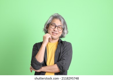 The Senior Asian Man With Smart Casual Dressed Standing Against The Light Green Background.