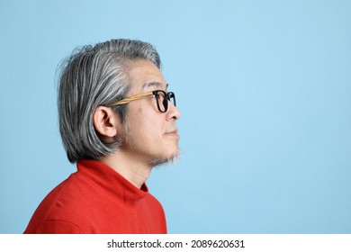 The Senior Asian Man Standing On The Blue Background.