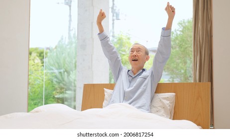 Senior Asian Man Stretching On The Bed