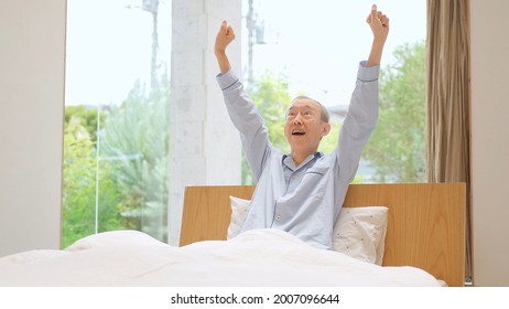 Senior Asian Man Stretching On The Bed