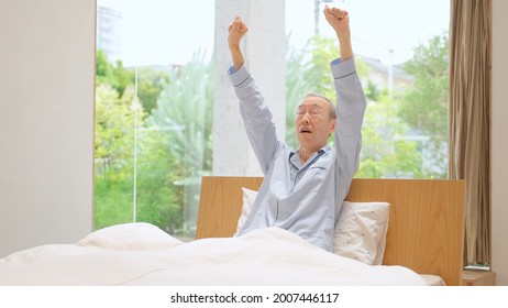 Senior Asian Man Stretching On The Bed