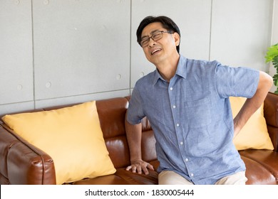 Senior Asian Man Suffering From Pain In The Back And Waist At Home