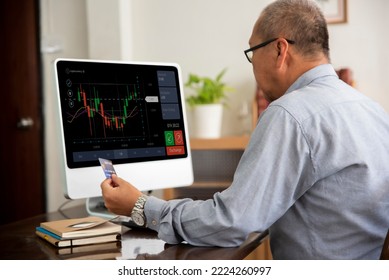 Senior Asian Man Using Computer Trading Stock Market Exchange Online At Home.