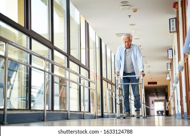 senior asian man walking using a walker in hallway of nursing home - Powered by Shutterstock