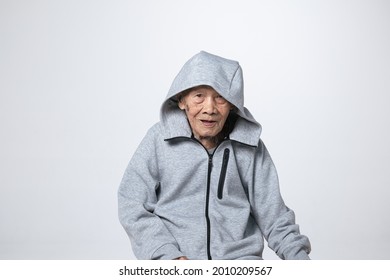 Senior Asian Man Wearing A Hoodie Sweater Or Cold Weather Zip Sweatshirt. A 95 Years Old Guy With A Cataract Eye Problem With A Gray 
Cool Shirt.