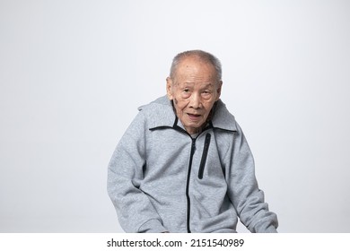 Senior Asian Man Wearing A Hoodie Sweater Or Cold Weather Zip Sweatshirt. A 95 Years Old Guy With A Cataract Eye Problem With A Gray 
Cool Shirt.