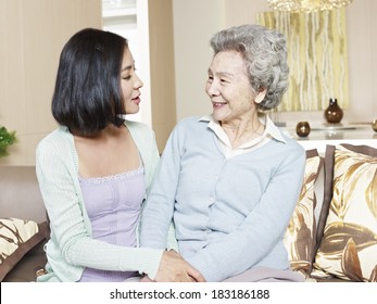 Senior Asian Mother Chatting With Adult Daughter At Home