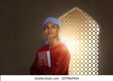 Senior Asian Muslim Man Carrying Holy Book Of Muslims On The Mosque