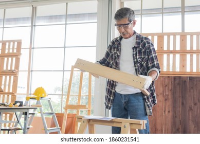 Senior Asian Old Man Carpenter Wearing Glasses And Gloves Protection Building Diy Furniture In Workshop