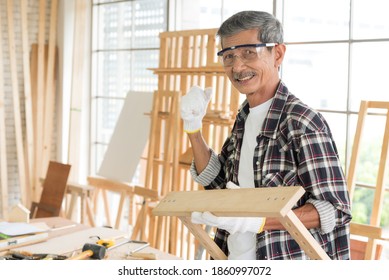 Senior Asian Old Man Carpenter Wearing Glasses And Gloves Protection Building Diy Furniture In Workshop