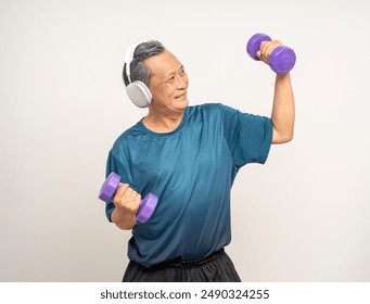 Senior asian old man with sportswear with headset lifting dumbbells on isolated white background. Happy healthy fit and firm attractive sporty mature man standing pose exercise workout in studio. - Powered by Shutterstock