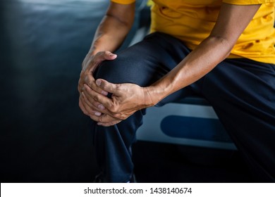 Senior asian sport man injury knee pain  sitting on treadmill in fitness gym . aged  suffering from Arthritis elder male exercising , workout, training ,healthy ,Retirement ,older, close up