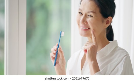 Senior Asian Woman Brushing Her Teeth. Dental Care. Oral Care.
