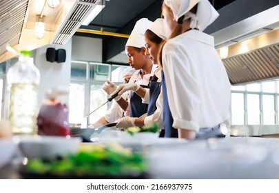 Senior asian woman chef teach student. Cooking class. culinary classroom. group of happy young woman multi-ethnic students are focusing on cooking lessons in a cooking school.  - Powered by Shutterstock