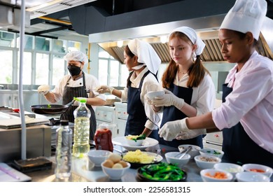 Senior asian woman chef teach student. Cooking class. culinary classroom. group of happy young woman multi-ethnic students are focusing on cooking lessons in a cooking school.  - Powered by Shutterstock