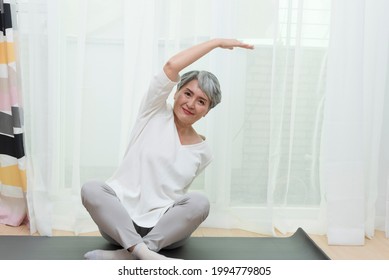 Senior Asian Woman Doing Sports At Home On A Mat, Healthy Lifestyle Concept.