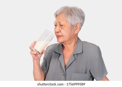 Senior Asian Woman Drinking Milk Isolated On White Background.