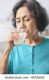 Senior Asian Woman Drinking Milk At Home