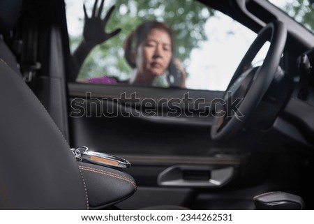 Senior asian woman  forgot her key inside locked car.