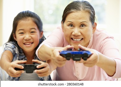 Senior Asian Woman And Girl Playing Video Game