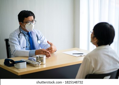 Senior Asian Woman Patient Consultation With Doctor In Doctor Clinic, They Are Using Face Mask For Prevention. Patient Care, Diagnose Concept