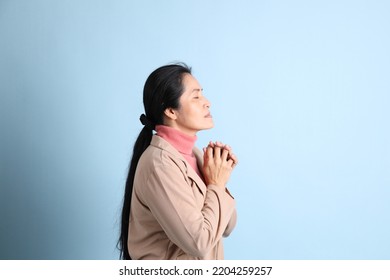 The Senior Asian Woman With Pink Shirt Brown Blazer On The Blue Background.