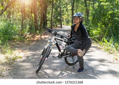 Senior asian woman stretch muscles with riding bikes in park - Powered by Shutterstock