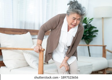 Senior Asian Woman Suffering From Knee Pain At Home.