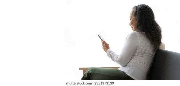 Senior Asian woman using mobile phone calling someone while relaxing at home. - Powered by Shutterstock