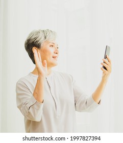 Senior Asian Woman Using Or Talking On Her Mobile Phone.