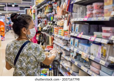 Senior Asian Woman Who Wear Surgical Face Mask Is Looking At Grocery Goods On The Shelf While Shopping In Supermarket. Lifestyle During Covid-19 (Coronavirus) Pandemic Situation Concept.