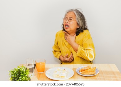 Senior asian women have acid reflux problems. While eating patty, food stuck in the throat, esophageal burning sensation, irritation, coughing, suffocation and difficulty swallowing.