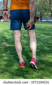 Senior Athlete Man With Muscle Pain During Training Outdoors. Thigh Muscle Cramps Trauma. View From The Back. Vertical Orientation.