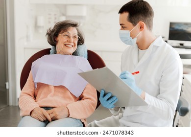 Senior, attractive woman, patient visiting professional doctor, talking, dentist writing down complaints, working in modern dentistry. Concept of health care, dental treatment - Powered by Shutterstock