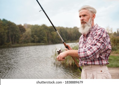 Senior Bearded Man Fishing On A Lake, Copy Space