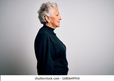 Senior Beautiful Woman Wearing Casual Black Sweater Standing Over Isolated White Background Looking To Side, Relax Profile Pose With Natural Face With Confident Smile.