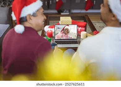 Senior biracial man and his adult son having christmas video call with senior african american woman. Communication technology and christmas, digital composite image. - Powered by Shutterstock