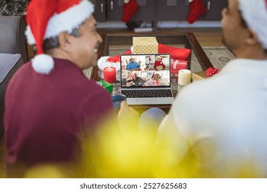 Senior biracial man and his adult son having christmas video call with diverse people. Communication technology and christmas, digital composite image. - Powered by Shutterstock