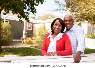 Senior Black Couple Look To Camera Outside Their New House