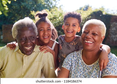 Senior black couple sitting outdoors with grandchildren