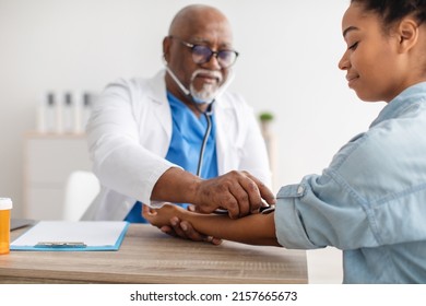 Senior Black Male Physician Manually Takes Blood Pressure Using Sphygmomanometer With Stethoscope, Checking Arterial Pressure. Hypertension, Hypotension, Cardiovascular Diseases Control Concept