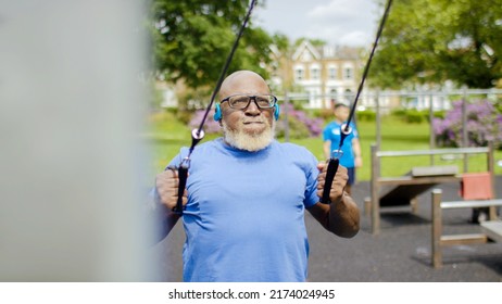 Senior Black Male Working Out With Weighted Bands In An Outdoor Gym Area