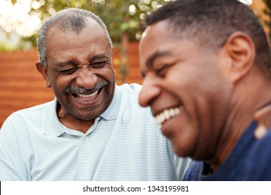 Senior Black Man And His Adult Son Laughing Together Outdoors, Close Up