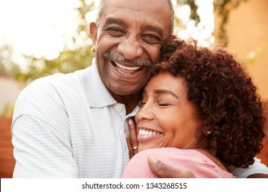 Senior black man and his middle aged daughter embracing, close up