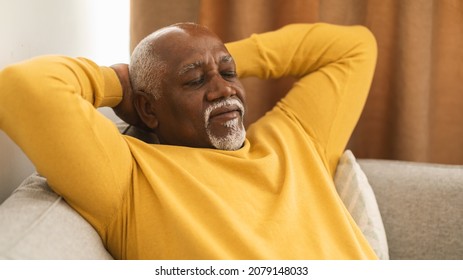 Senior Black Man Sleeping Holding Hands Behind Head Sitting On Sofa At Home. Mature Male Relaxing Resting With Eyes Closed, Napping On Couch. Rest And Relaxation Concept. Panorama - Powered by Shutterstock