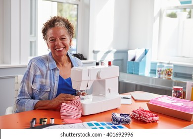 Senior Black Woman Using A Sewing Machine Looking To Camera