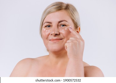 Senior blonde woman with cream mask under the eyes. Beautiful woman with perfect skin and cream contour anti-aging and wrinkle eyes. Concept of beauty and perfection