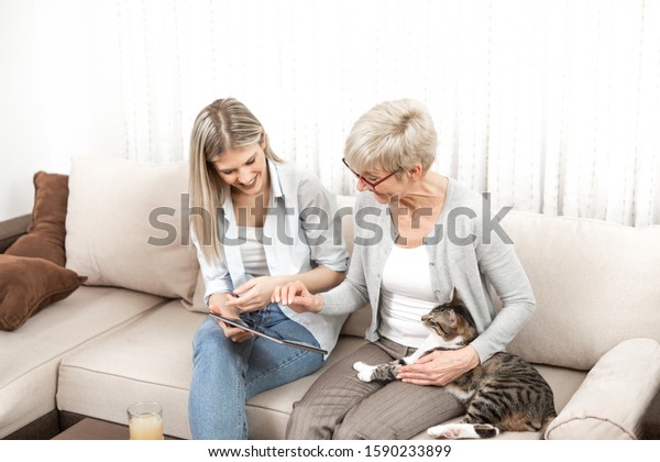A\
senior blonde woman learns to use a tablet computer. She wants to\
learn how to buy cat food online. But she also wants to know how to\
watch tv online, shop online and use social networks\
